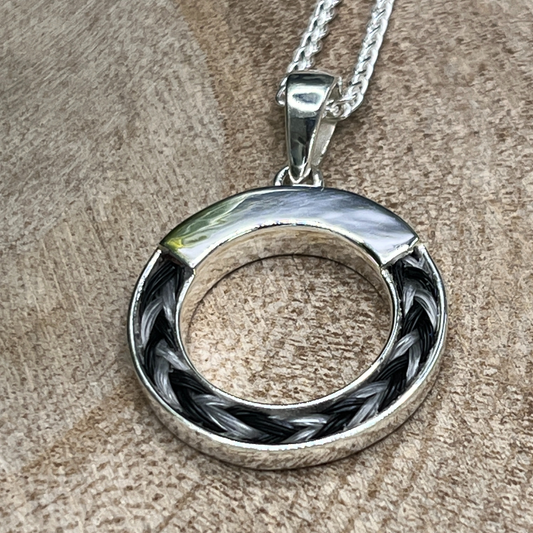 Silver pendant necklace on a wooden surface