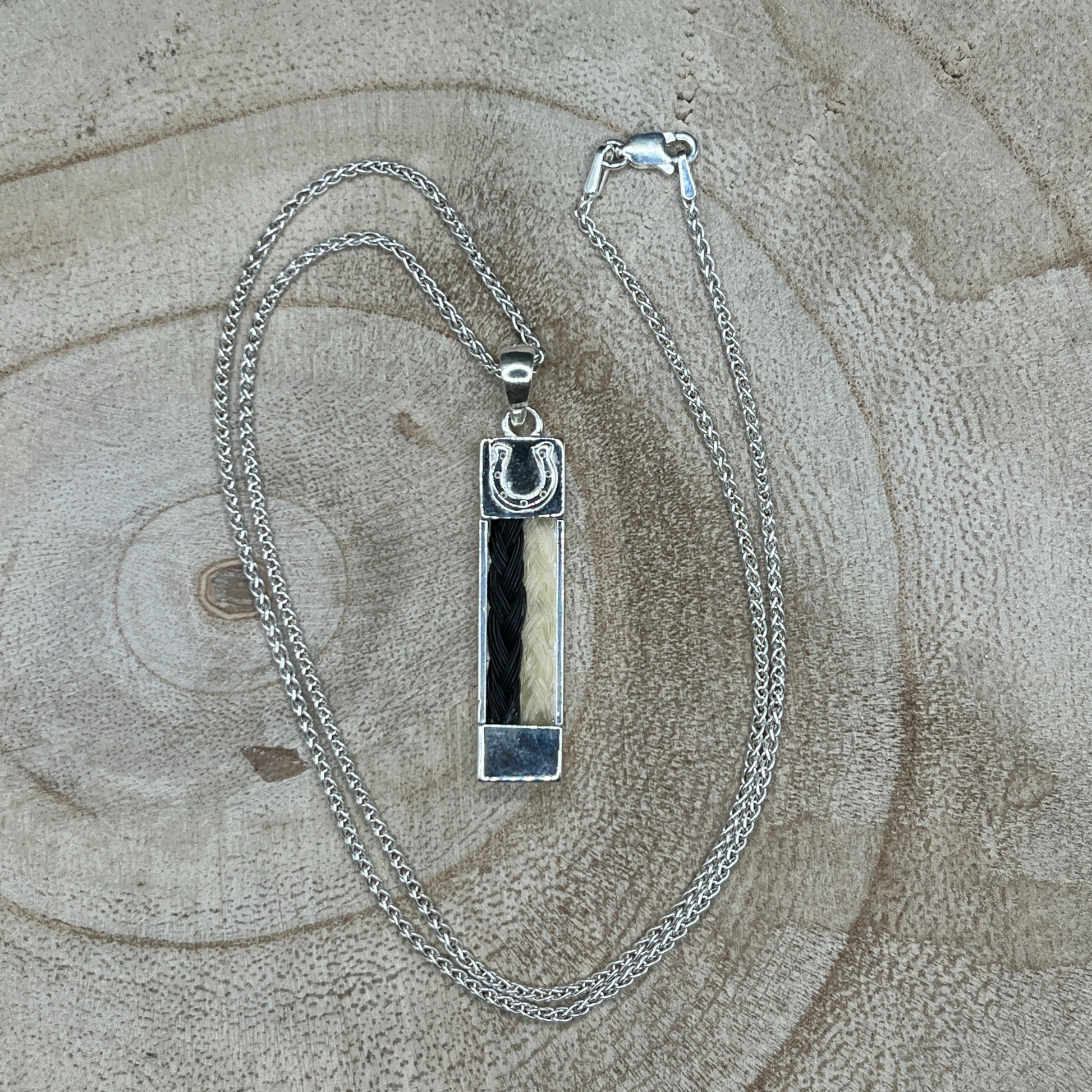 Sterling silver bar pendant with two braided horse hair strands from different horses.