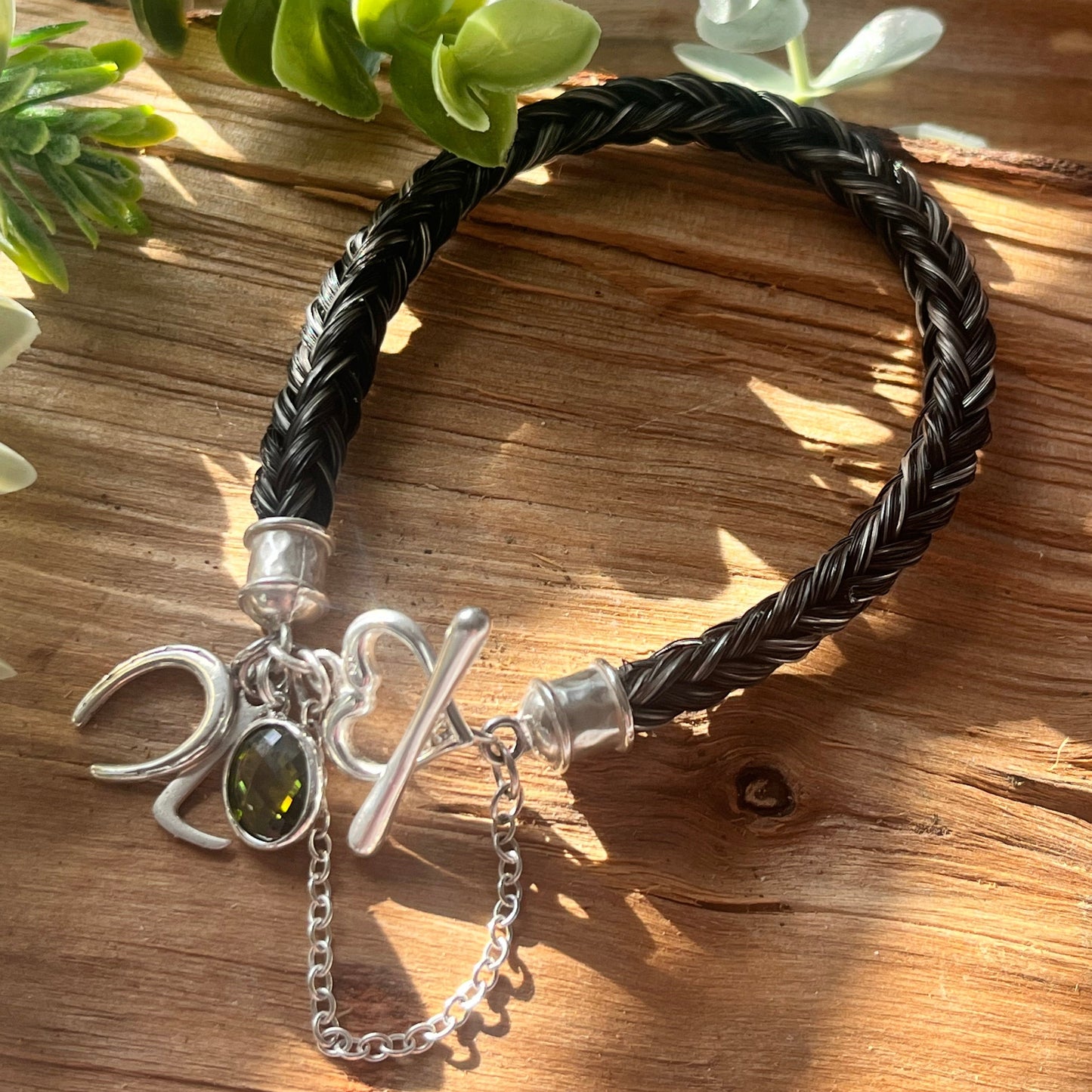 Heart-shaped sterling clasp on custom horsehair bracelet with horseshoe charm