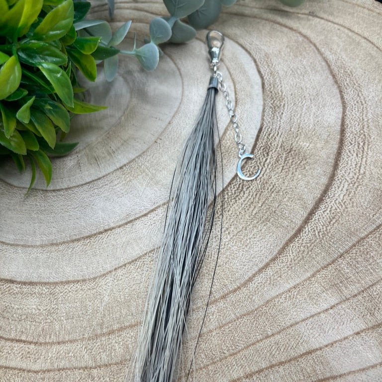 Hand-strung horsehair tassel keepsake with polished silver cap and secure clasp