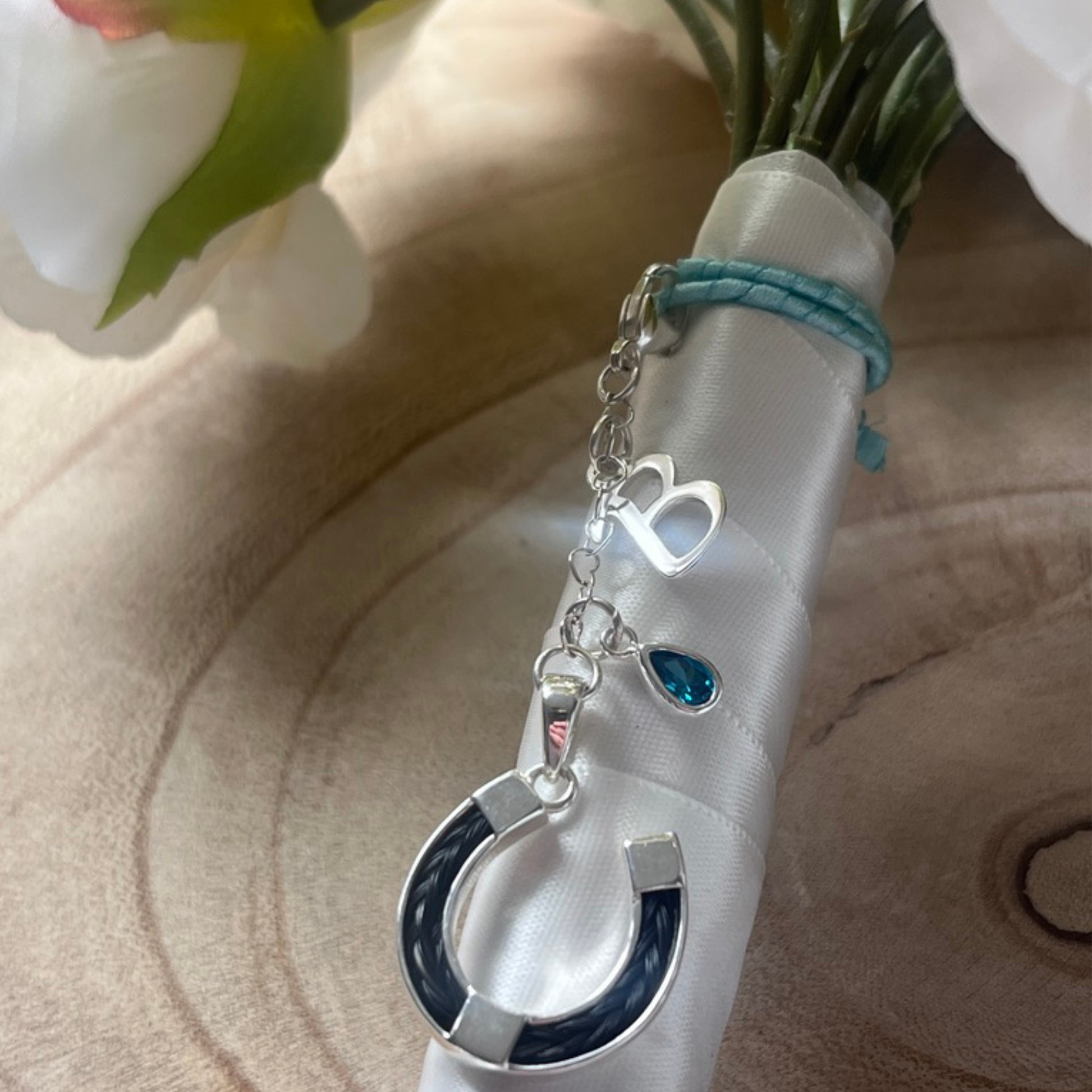 Silver horsehair charm with charms on a bouquet of flowers